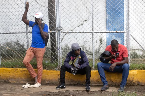 Haitianos llegan a preguntar por familiares detenidos en el centro de recepción de migrantes este lunes en Haina (República Dominicana). | EFE