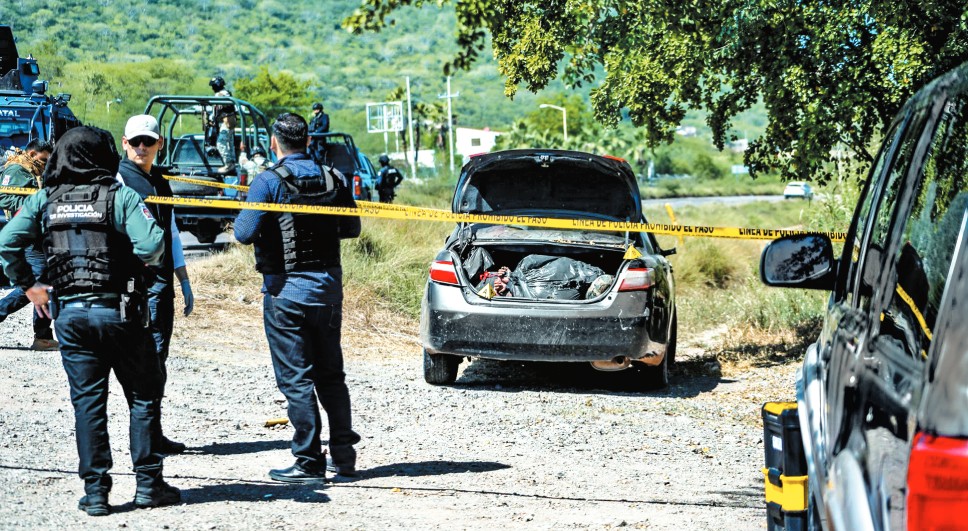 Autoridades resguardan un automóvil con dos cuerpos maniatados en la cajuela en Culiacán. Cuartoscuro