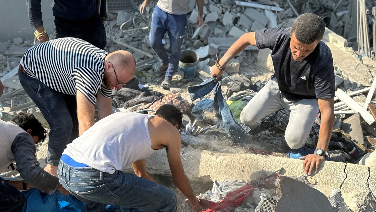Personas tratan de recuperar los cuerpos de palestinos que se encontraban en las viviendas atacadas por Israel al norte de Gaza | REUTERS