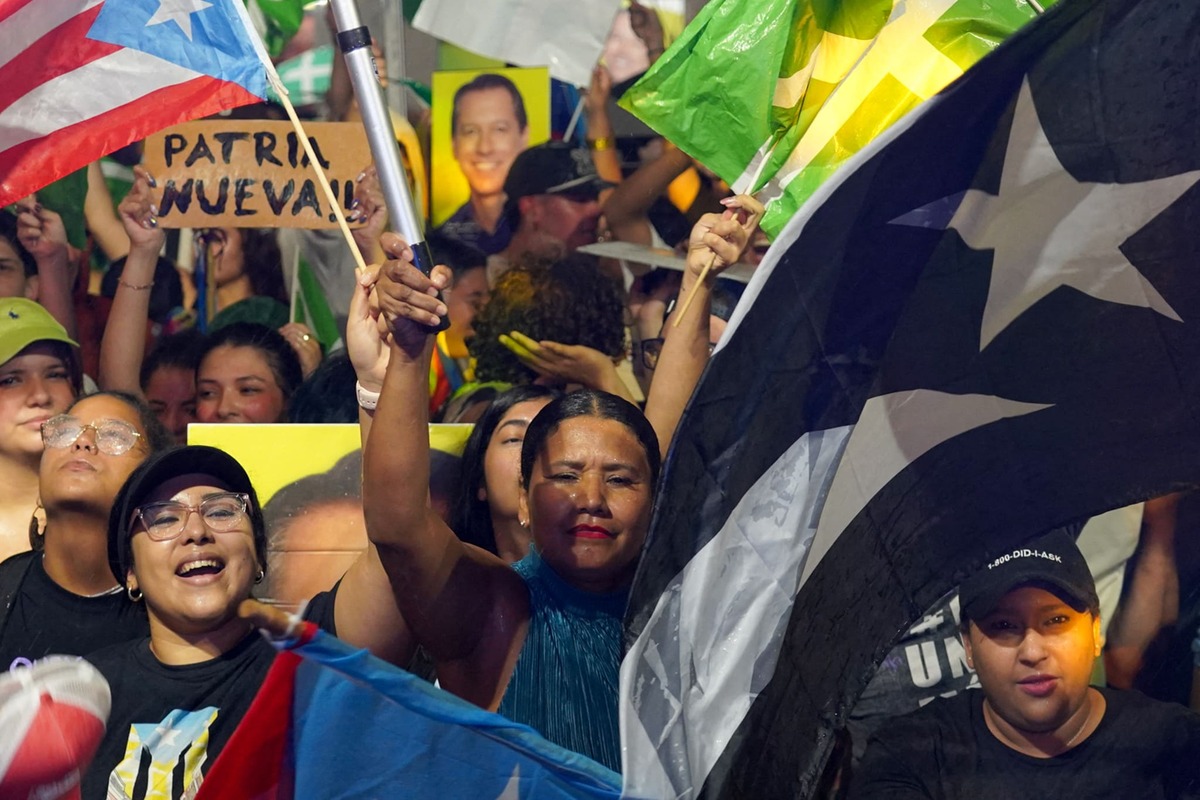 La gente ondea banderas de Puerto Rico y del Partido Independentista Puertorriqueño mientras reaccionan a los resultados de las elecciones | AFP
