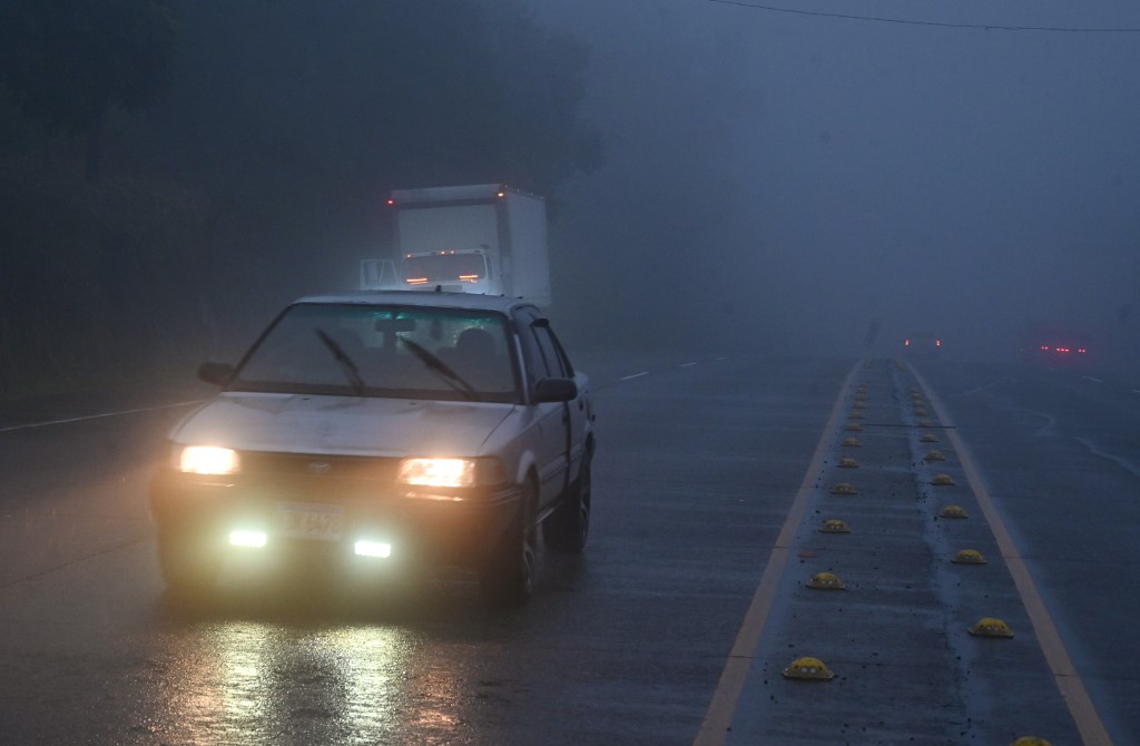 Un automóvil conduce a través de una densa niebla antes de la llegada de la tormenta tropical Sara a Siguatepeque, Honduras | AFP