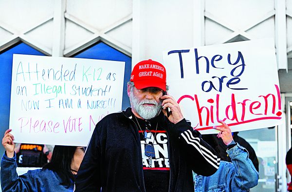 Un partidario de Trump en medio de una protesta contra redadas en escuelas públicas y un grupo de repatriados bajo la ley Título 8 en Texas. REUTERS