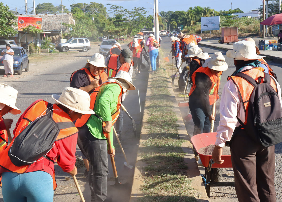 Migrantes limpian una calle este sábado, en Tapachula, Chiapas. | EFE