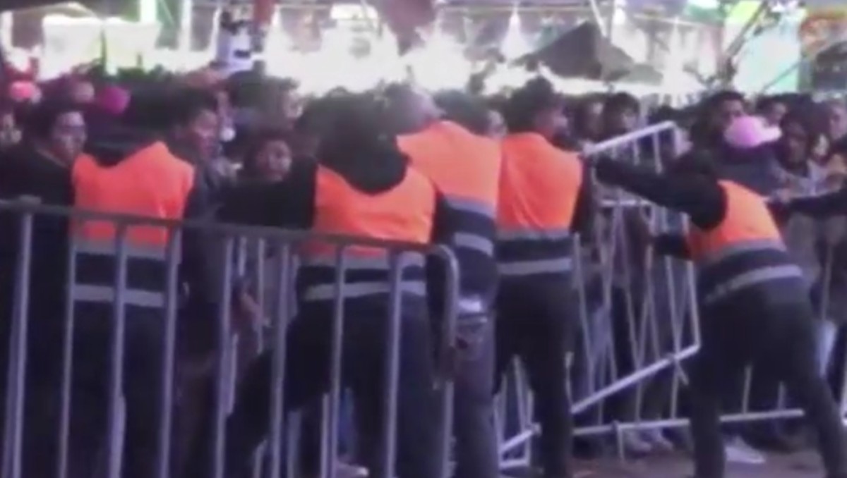 Asistentes empujan las vallas metálicas en la Feria de Tizayuca