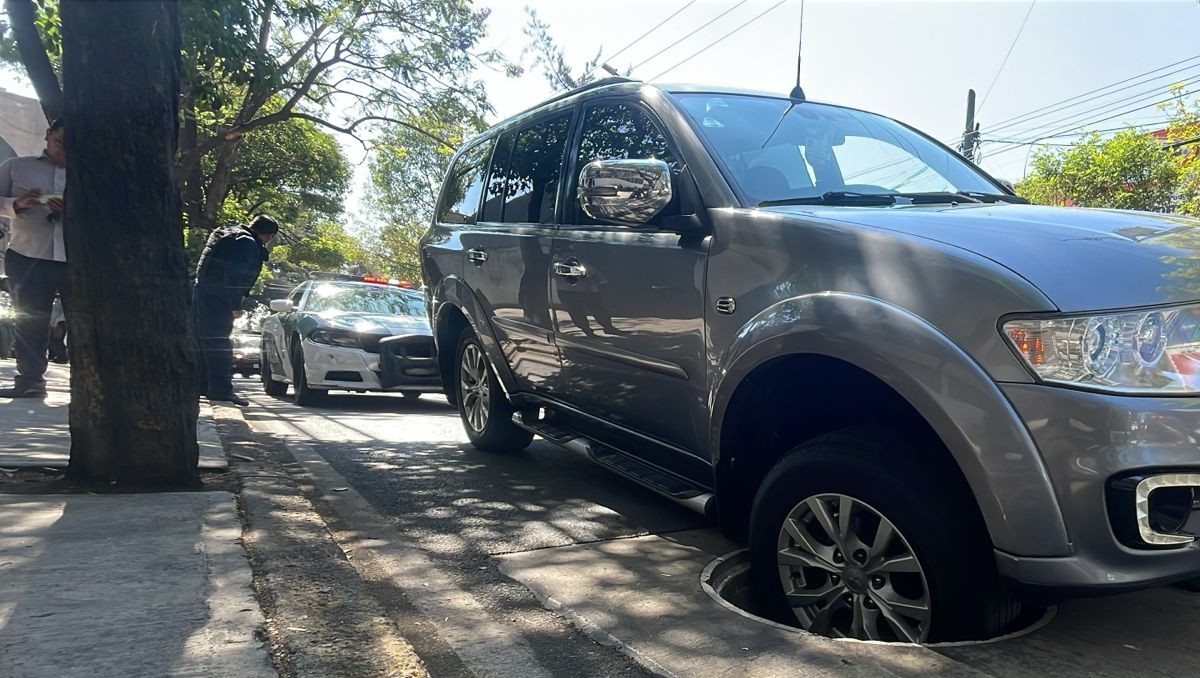 Autoridades acordonaron el área tras el daño a dos vehículos por una coladera abierta. | Luis Alfaro