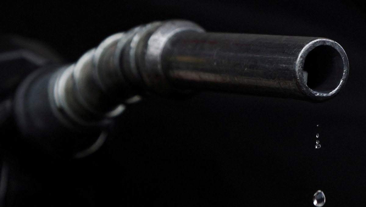 Gasolina gotea de surtidor sostenido por trabajador de gasolinera en Somerville, Massachusetts, EU. Marzo de 2022. Foto: Reuters