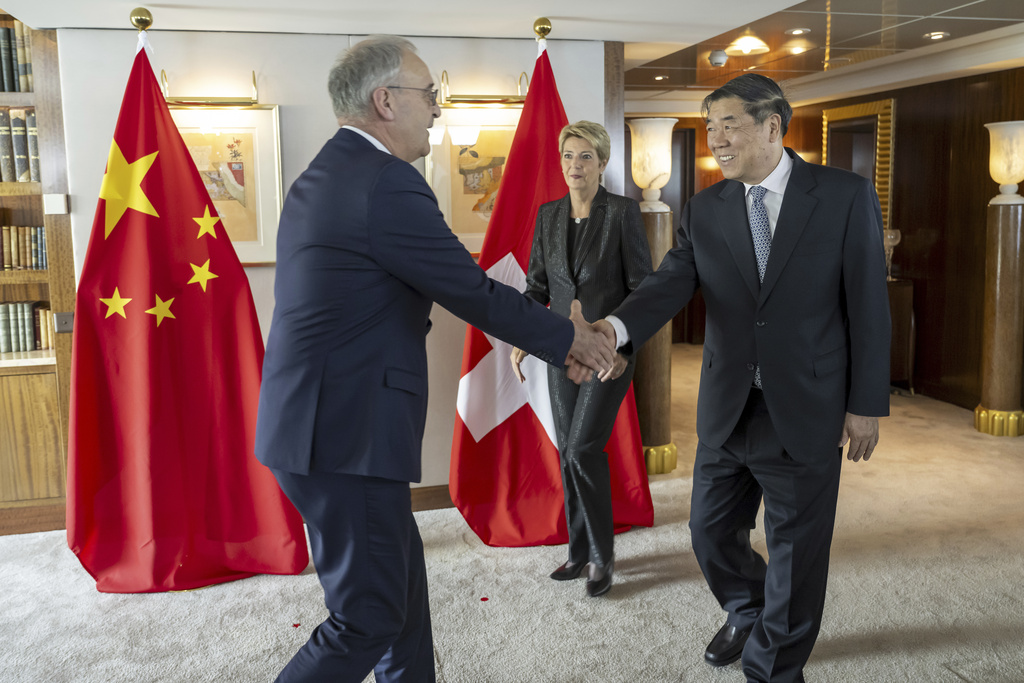 El ministro de Economía de Suiza, Guy Parmelin y el vice primer ministro chino, He Lifeng, junto a la presidenta de Suiza, Karin Keller-Sutter. | AP