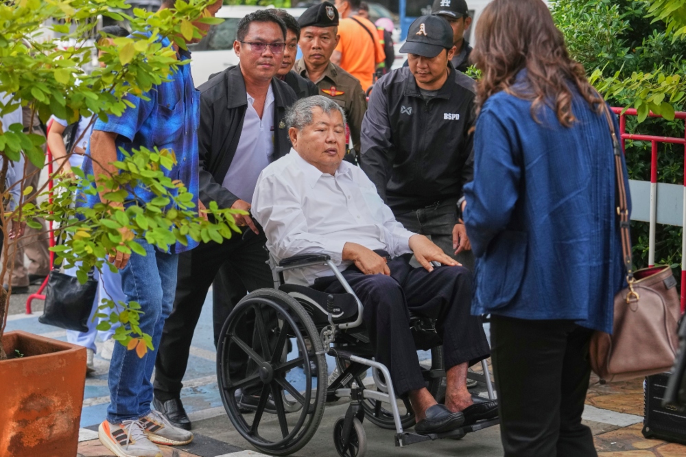 Premchai Karnasuta, presidente de la constructora italo-tailandesa Development Co, llega en silla de ruedas a la comisaría de Bang Sue, en Bangkok.AP