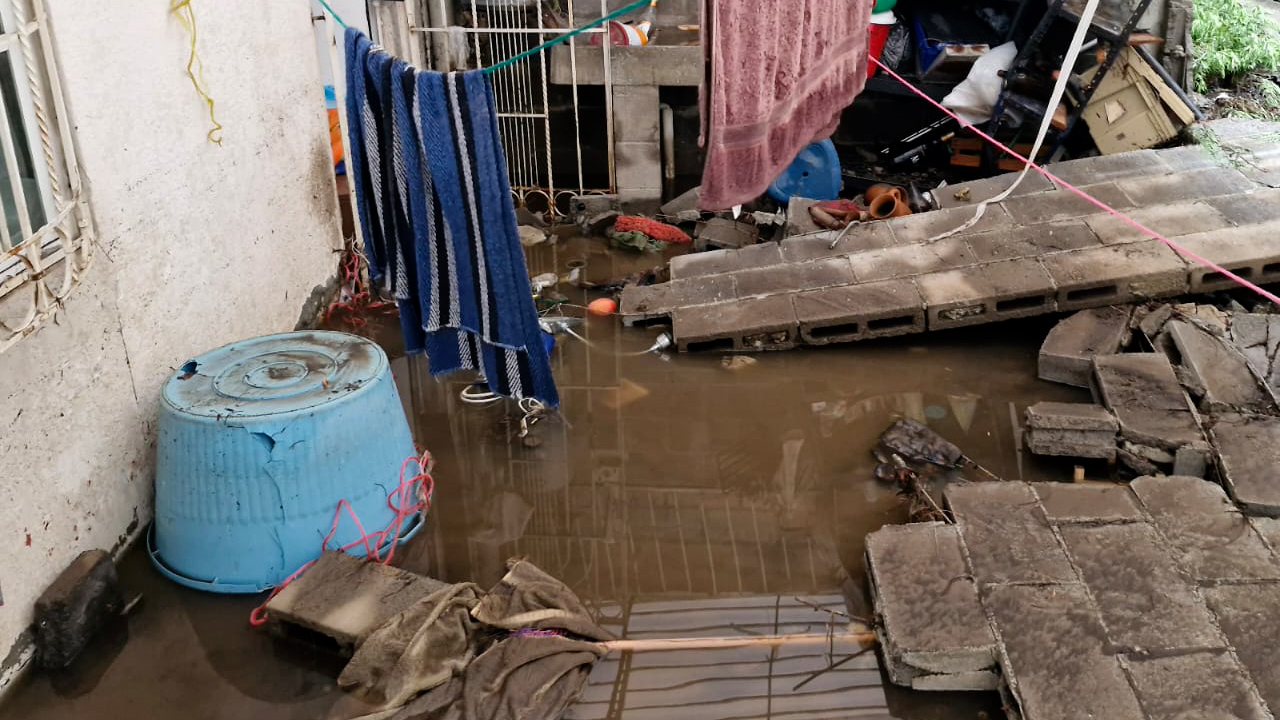 Escurrimiento de lluvia arrasa con vivienda y derriba barda trasera en Pachuca