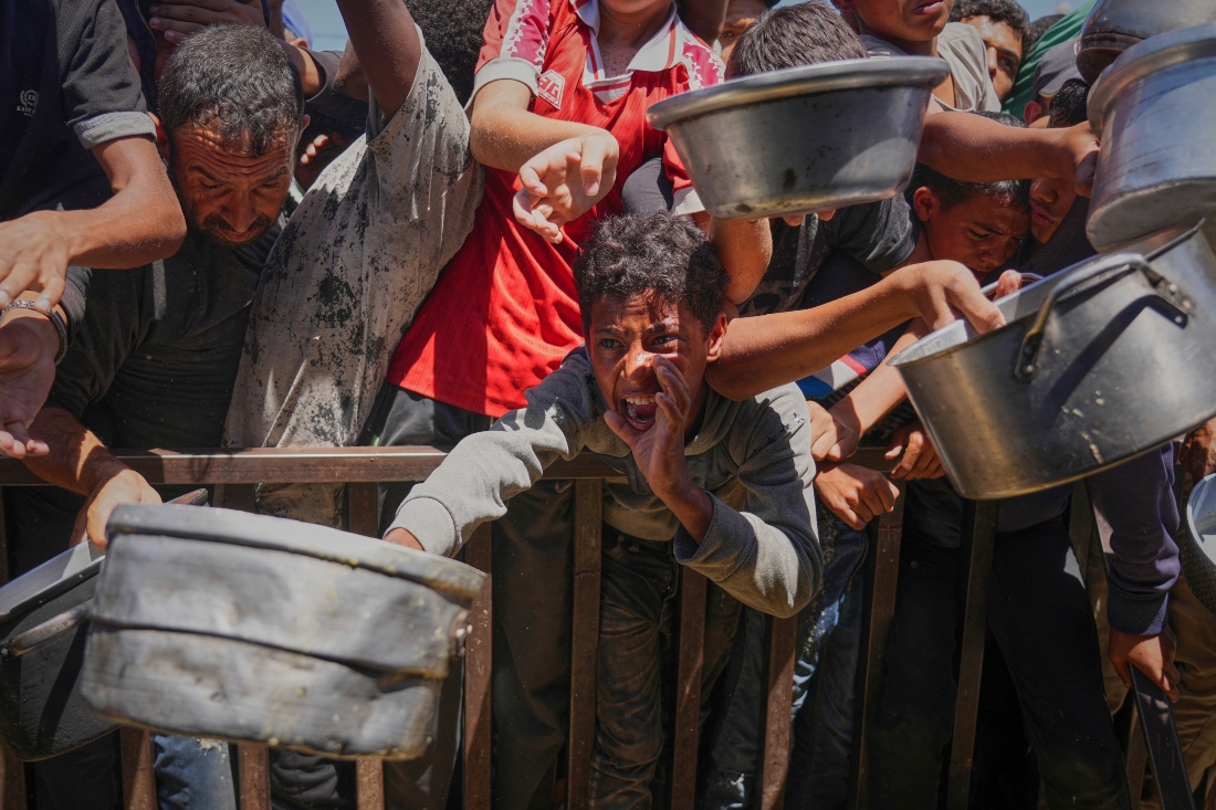 Palestinos luchan por recibir comida distribuida en una cocina comunitaria en el área de Muwasi de Jan Yunis, en la Franja de Gaza. |AP