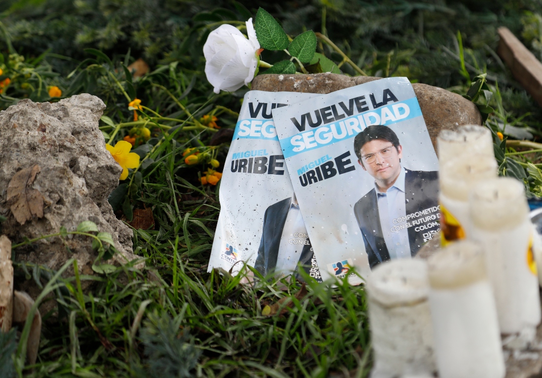 Panfletos con la imagen del senador colombiano Miguel Uribe Turbay, junto a velas y flores, colocadas junto al lugar en el que fue disparado. |AP