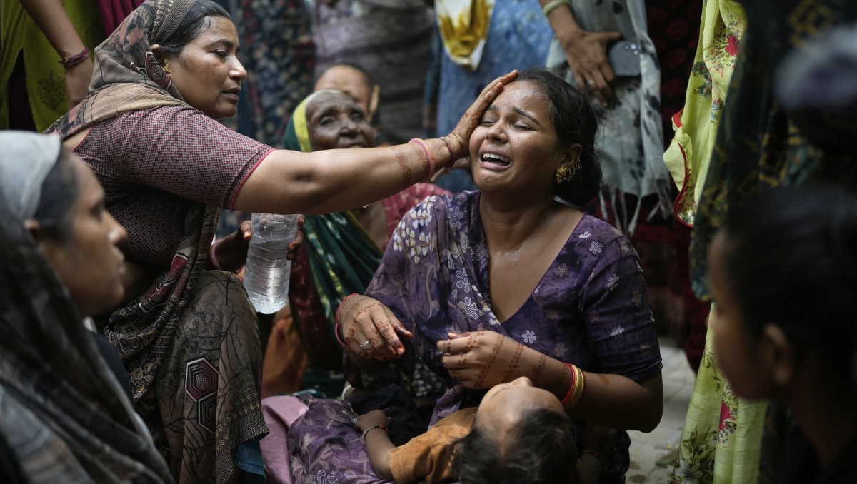 Un familiar de una víctima del accidente aéreo de Air India se consuela mientras se derrumba en un hospital en Ahmedabad, India. | AP