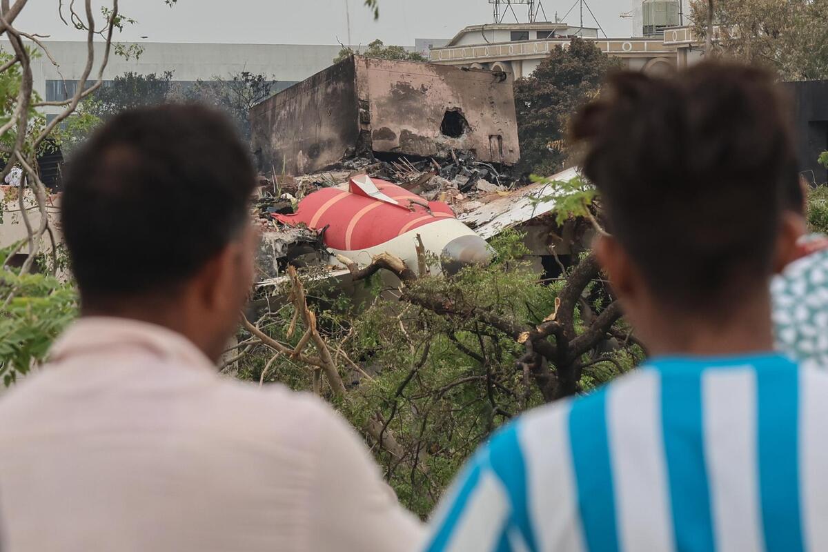 Personas observan los restos del avión de Air India accidentado. | EFE