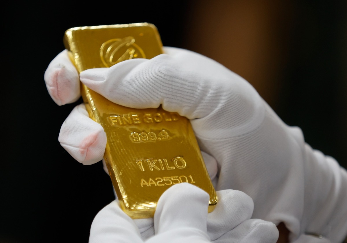 Un empleado sostiene una bandeja de joyas de oro en una joyería en Shanghái, China. | Foto: Reuters.