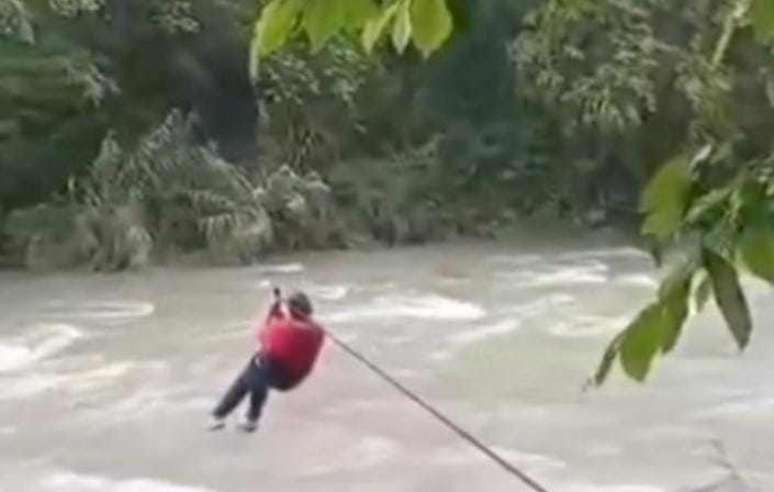 Maestra cruza Río a través de la tirolesa improvisada.