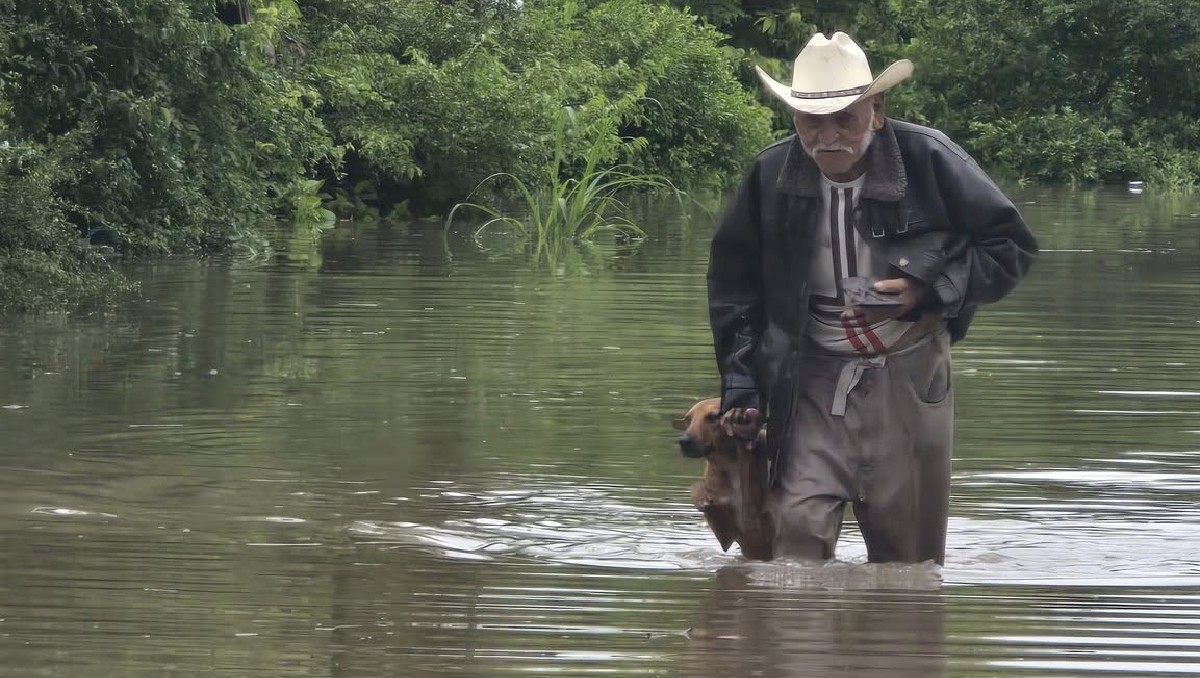Adulto mayor salva a su perrito de inundación. (Gladis Sierra Hernández)
