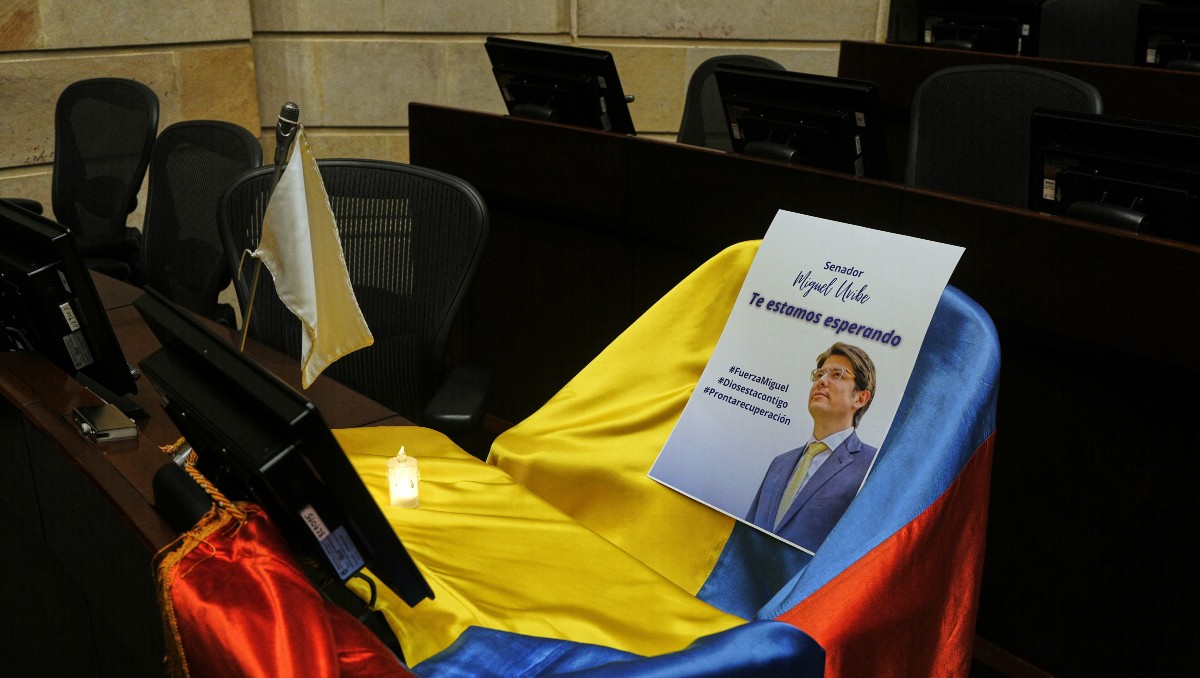 Un folleto muestra la imagen del senador colombiano Miguel Uribe Turbay sobre una bandera colombiana en el Congreso, en Bogotá. AP