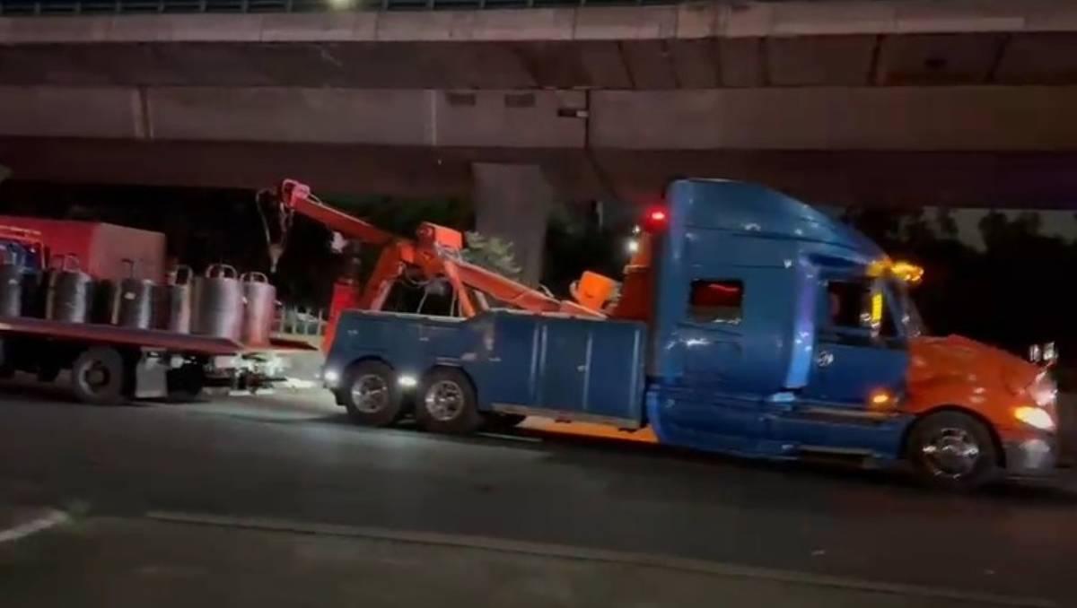 Un tráiler que transportaba pacas de cartón cayó en un enorme bache en los carriles centrales. | Especial