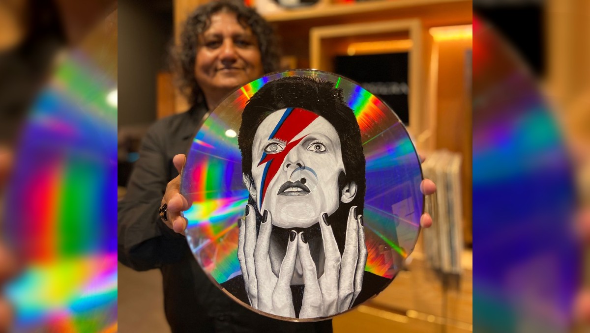 Alex Martínez Zaragoza y uno de sus vinilos intervenidos. (Martha Calvillo)
