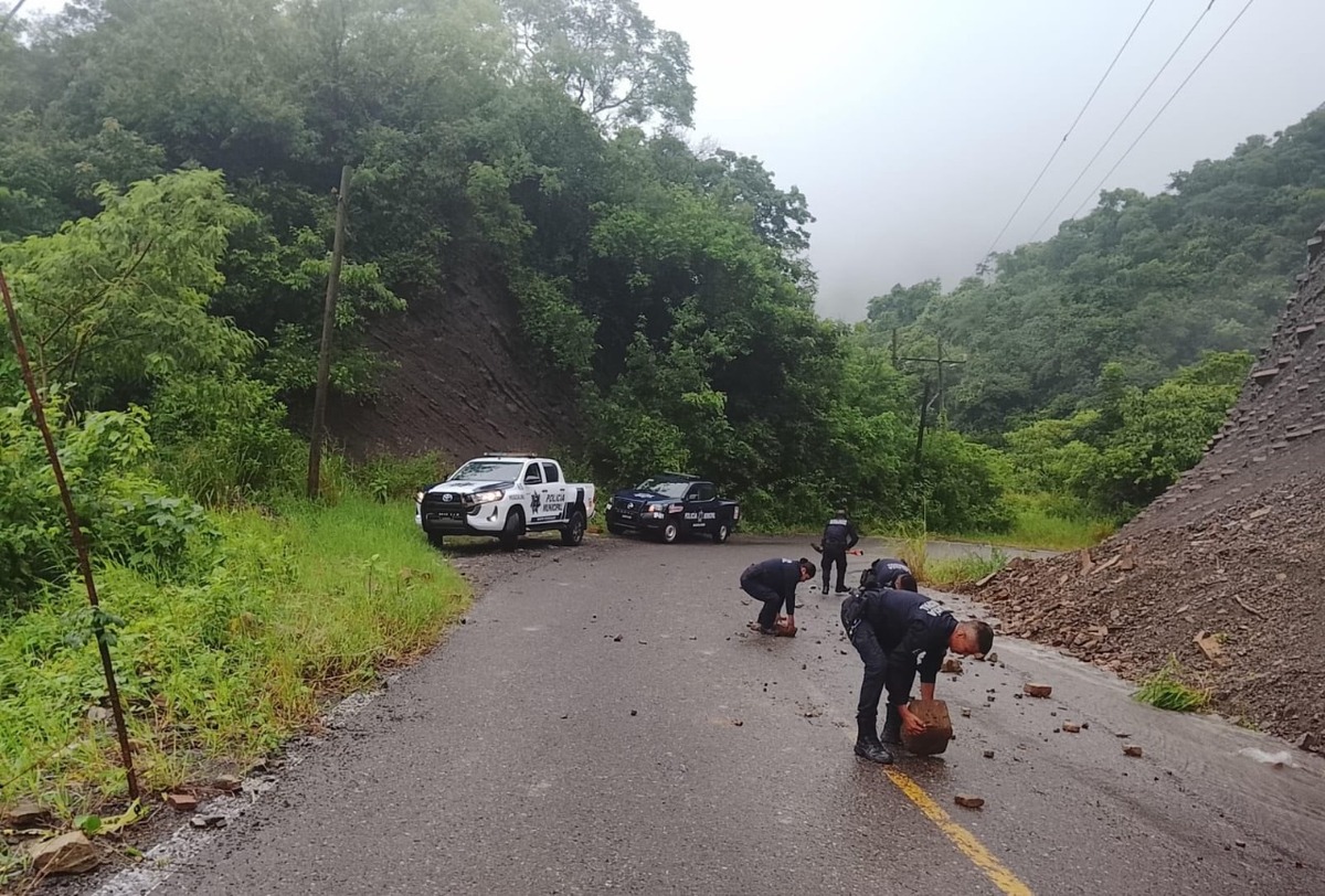 Policías apoyan a liberar caminos bloqueados por piedras y arboles. (Cortesía)