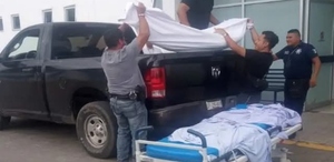 A través de redes sociales circularon fotografías del momento en que un cuerpo es subido a la batea de una camioneta de la Fiscalía para trasldarlo.
