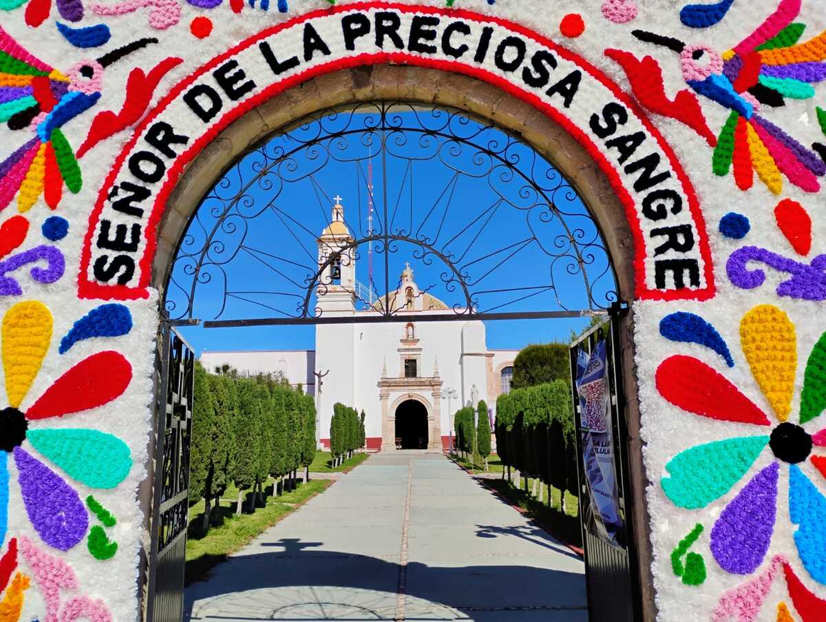 Arco de tenangos con el nombre del “Señor de la Preciosa Sangre”, dan la bienvenida a la parroquia. (Alejandro Reyes)