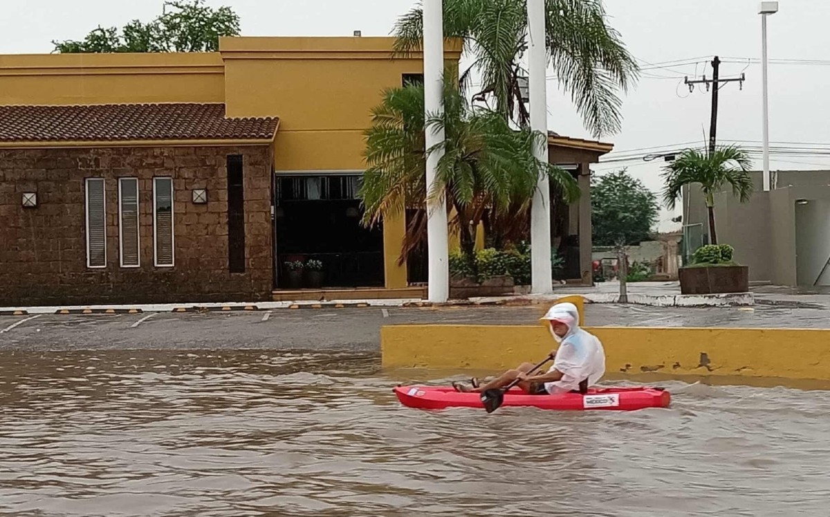 Hombre remando en kayak sobre avenida inundada. | Tiktok