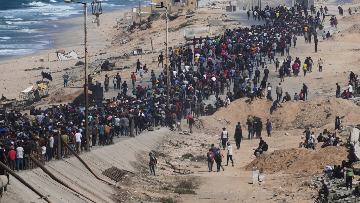 Palestinos caminan por la carretera costera en el centro de la Franja de Gaza, el 10 de octubre de 2025. | FOTO: AP / Abdel Kareem Hana
