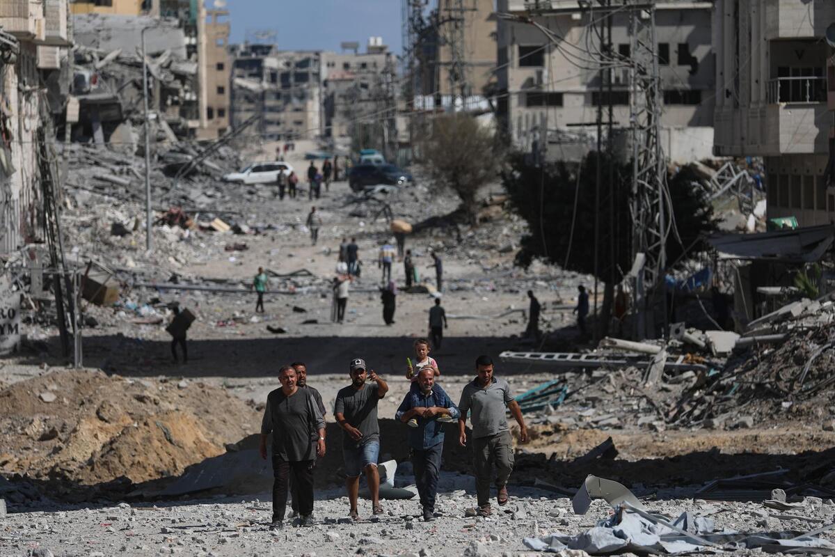 Palestinos caminan entre escombros durante un alto el fuego en Gaza. | EFE