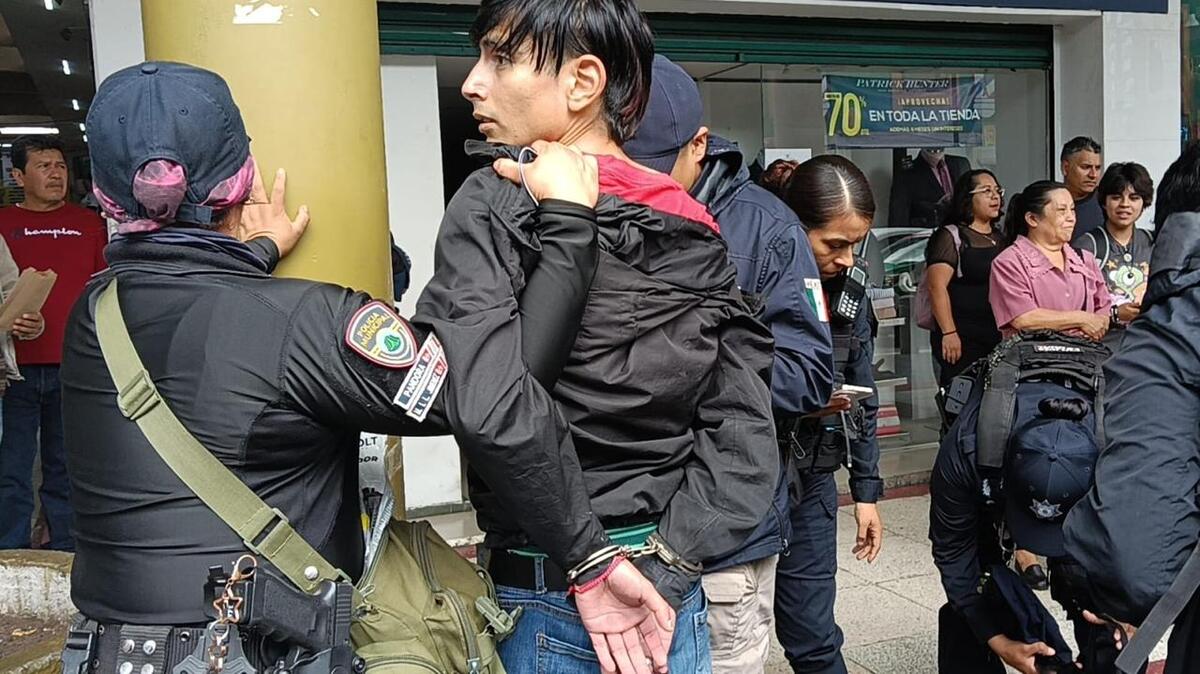 Presunto ladrón esposado siendo custodiado por elementos de la Policía Estatal en la calle Juan de la Luz Enríquez de Xalapa. | Especial