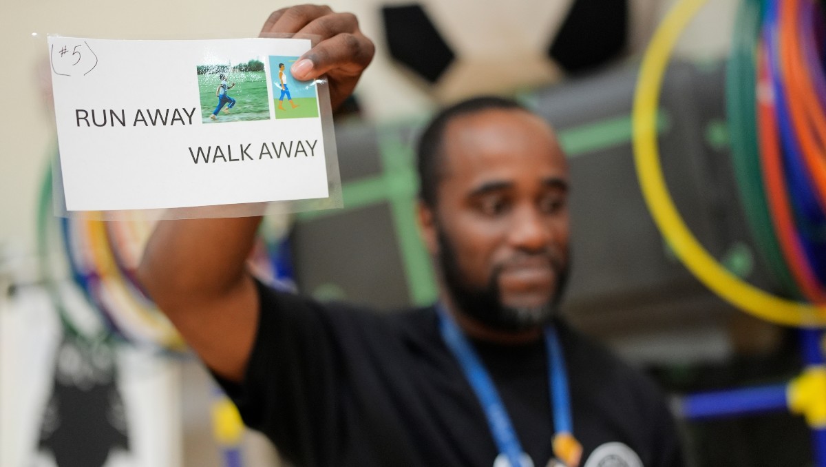 Un profesor muestra instrucciones que alumnos deben seguir cuando encuentran un arma de fuego | AP