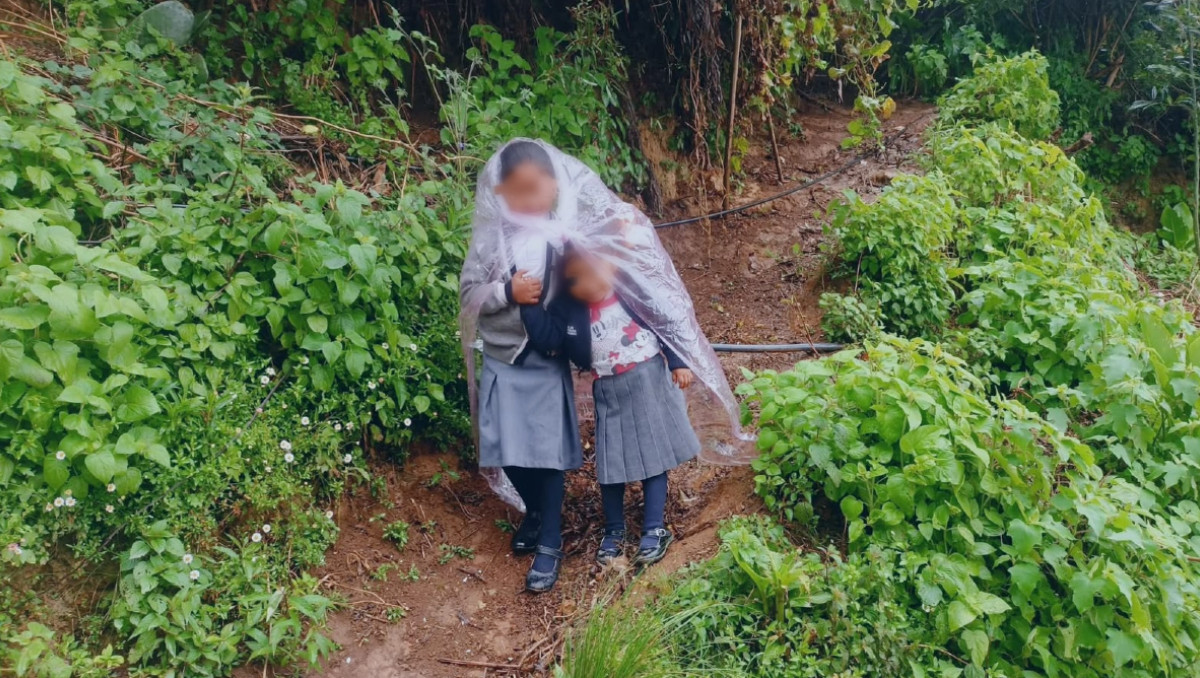Niños acuden a clases en la Sierra Negra cubiertos con plástico | Especial
