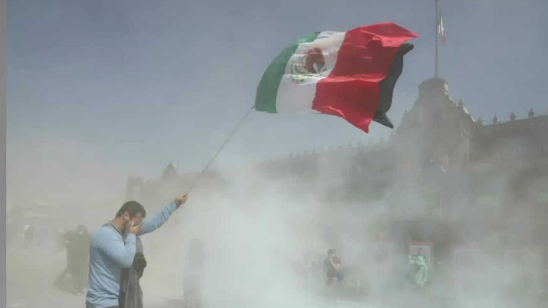 ¿A quién le pertenece la fotografía del hombre sosteniendo la bandera mientras se cubre el rostro?
