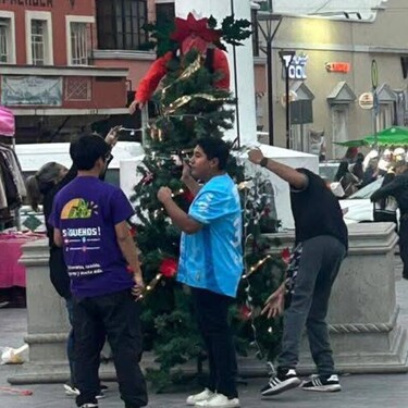 La falta de decoraciones oficiales motivó a dos jóvenes a instalar un pequeño árbol navideño en Plaza Juárez de Pachuca