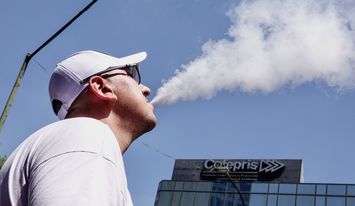 Imagen de una persona vapeando frente al edificio de la Cofepris | Cuartoscuro