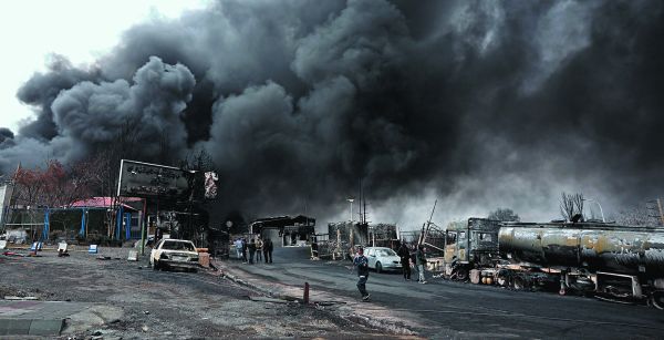 La puerta principal de la refinería de Shahran mientras aún se eleva el humo tras un ataque aéreo en Teherán. EFE
