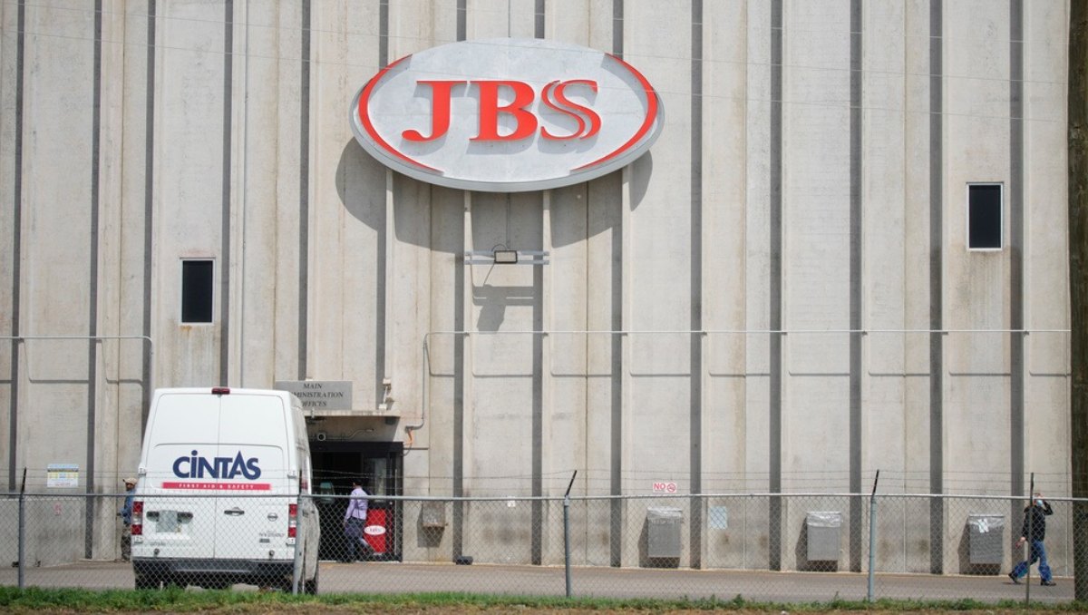 Empleados trabajan ante la entrada de la planta de procesamiento de carne de JBS, Greeley, Colorado. Foto: AP