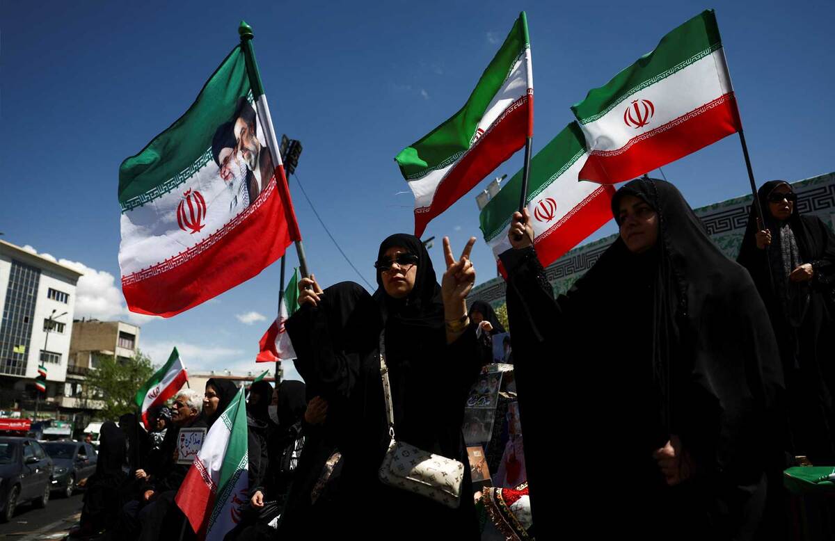 Ciudadanos Iraníes alzando la bandera de Irán. Reuters