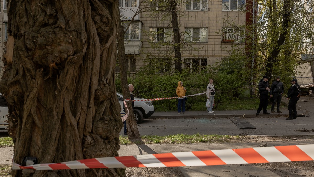 Policías ucranianos y residentes locales se congregan en el lugar de un ataque con drones rusos en Kiev. | AFP