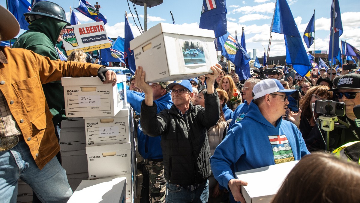 Simpatizantes cargan cajas con firmas para solicitar un referendo de separación a la Comisión Electoral de Alberta. | AP