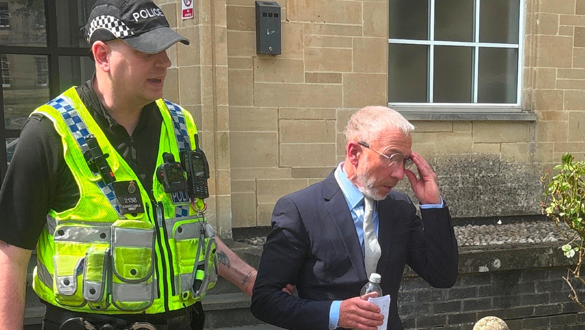 El cofundador de la empresa de ropa Superdry, James Holder, es escoltado por un policía. | AP