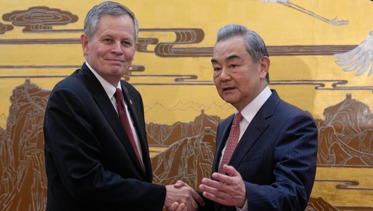 El senador estadunidense Steve Daines, a la izquierda, es recibido por el ministro chino de Exteriores, Wang Yi. | Foto: AP
