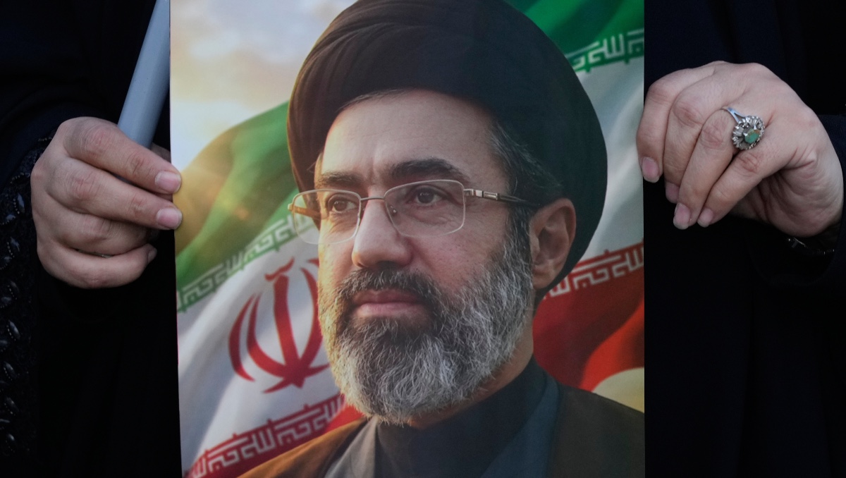 Mujer sostiene una imagen del líder supremo de Irán, el ayatolá Mojtaba Jamenei. | AP