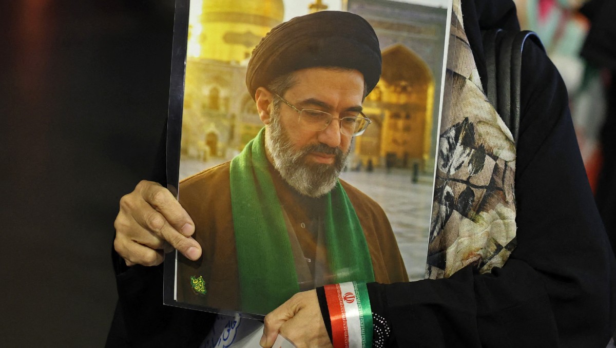 Mujer sostiene una pancarta con la foto del ayatolá Mojtaba Jamenei. | AFP