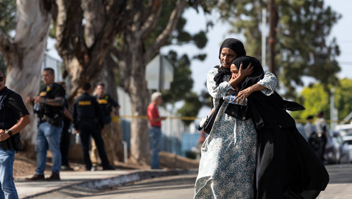 Dos mujeres reaccionan al salir de un centro de reunificación tras el tiroteo en el Centro Islámico de San Diego. | AFP