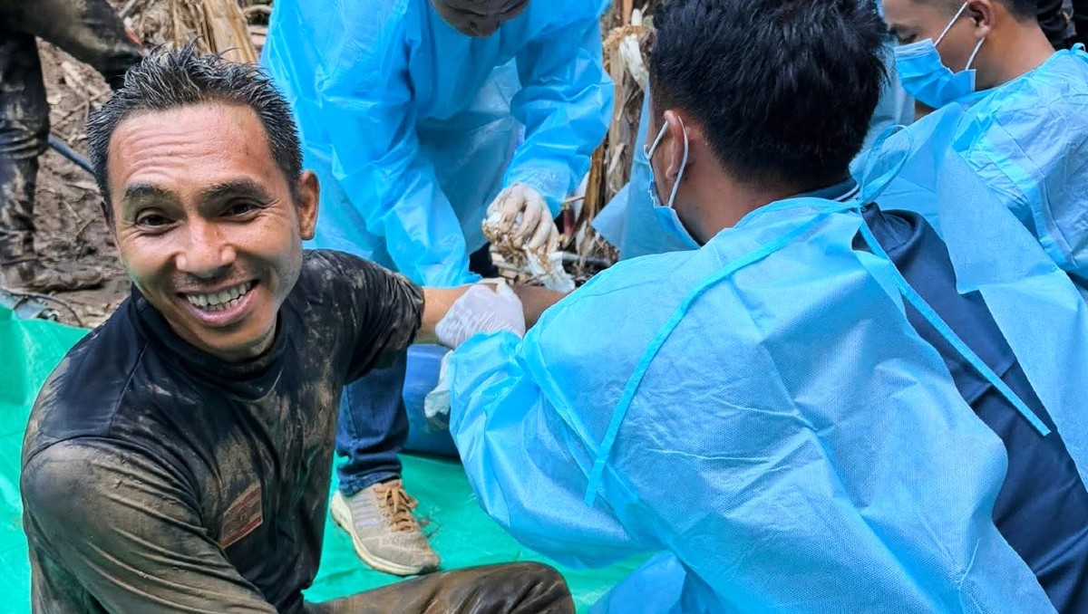 Rescatistas sentados tras rescatar a varias personas que pasaron días atrapados en una cueva en la provincia de Xaisomboun, Laos. | AP