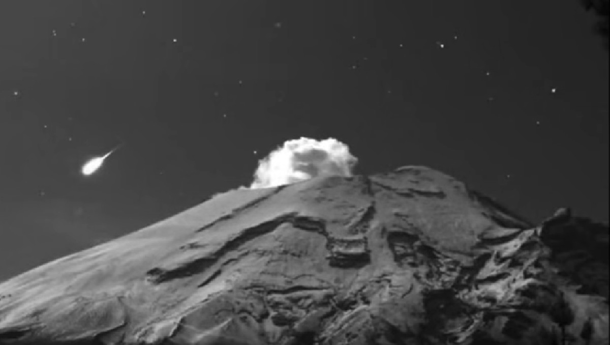 Bólido cruzando el cielo detrás del volcán Popocatépetl durante actividad volcánica en Puebla. | FOTO: Webcams de México