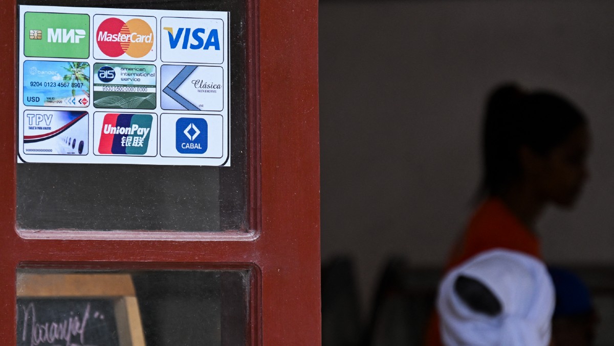 Establecimiento comercial exhibe varios tipos de tarjetas bancarias que se pueden utilizar para realizar pagos en La Habana. | AFP