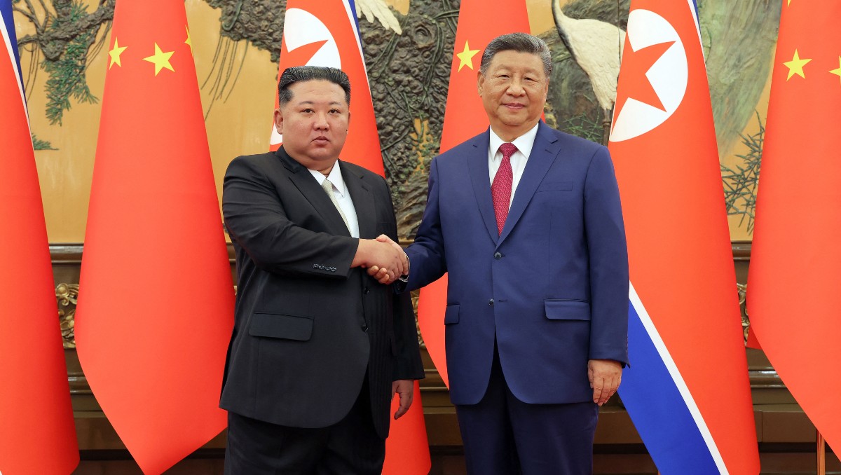 El líder norcoreano Kim Jong Un estrecha la mano del presidente chino Xi Jinping en Pekín. | AFP