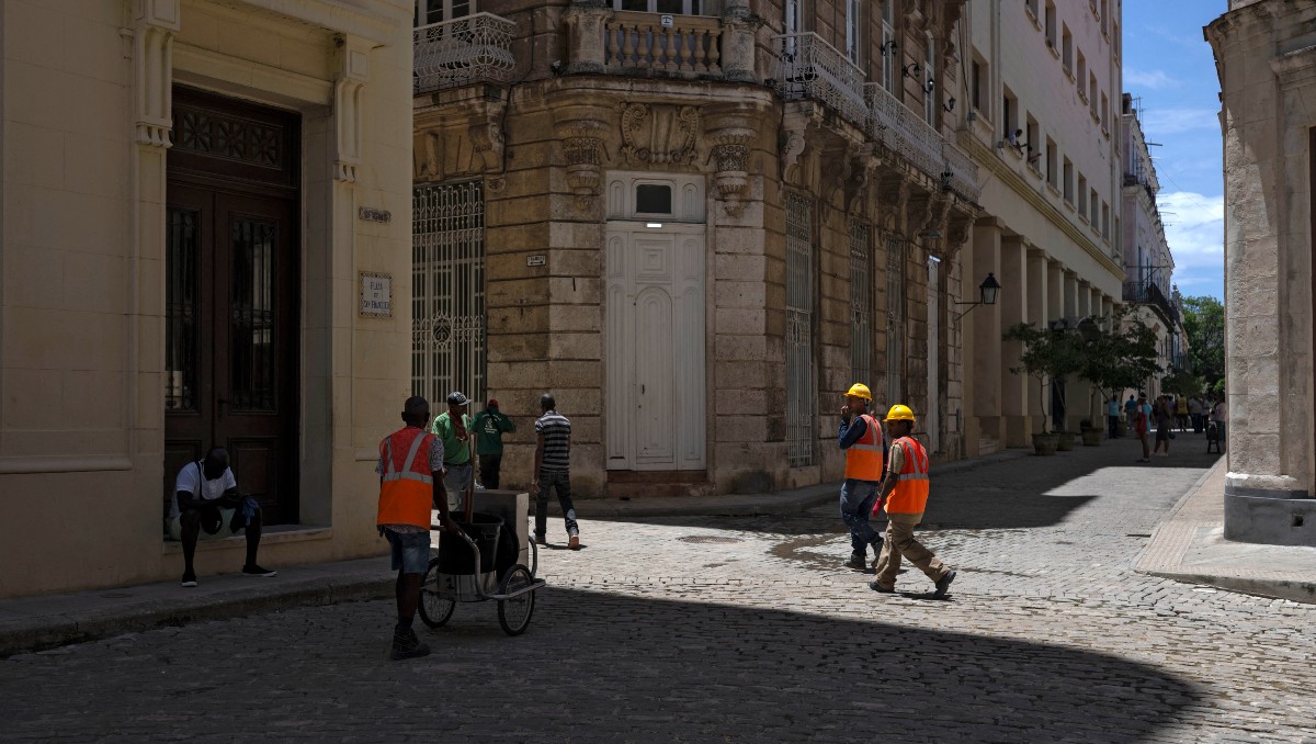Trabajadores en una calle tras evacuar sus oficinas debido a un temblor en La Habana. | AFP